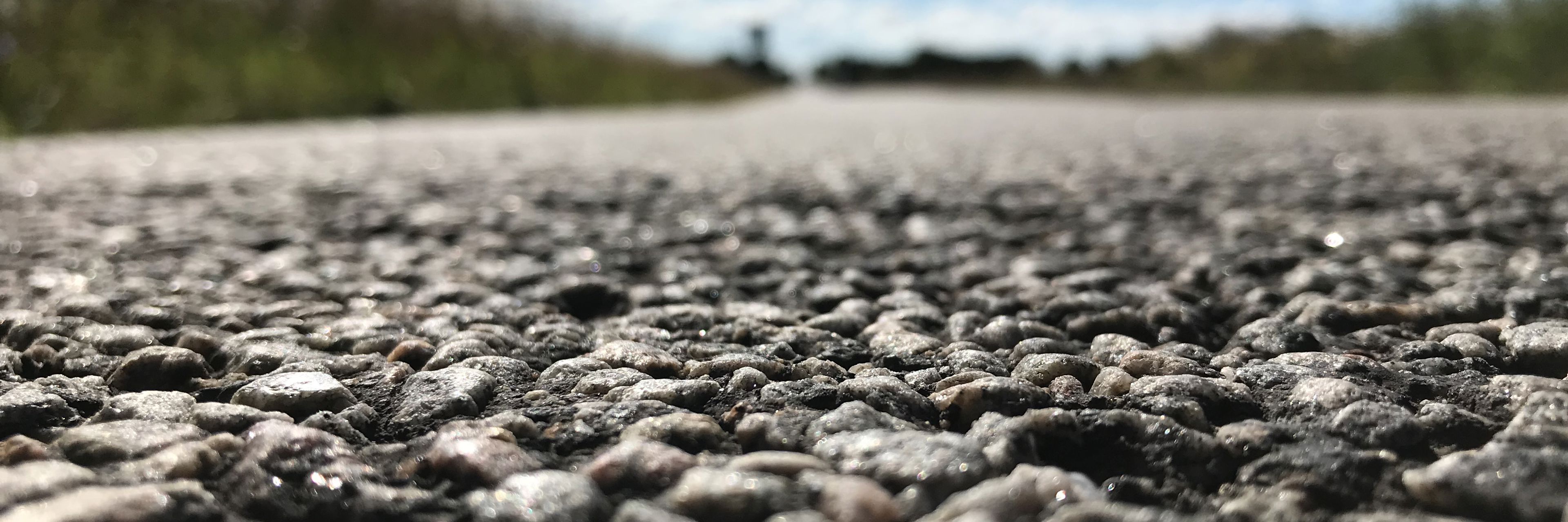 Closeup af en vej hvor man tydeligt ser de småsten en vejbelægning er lavet af