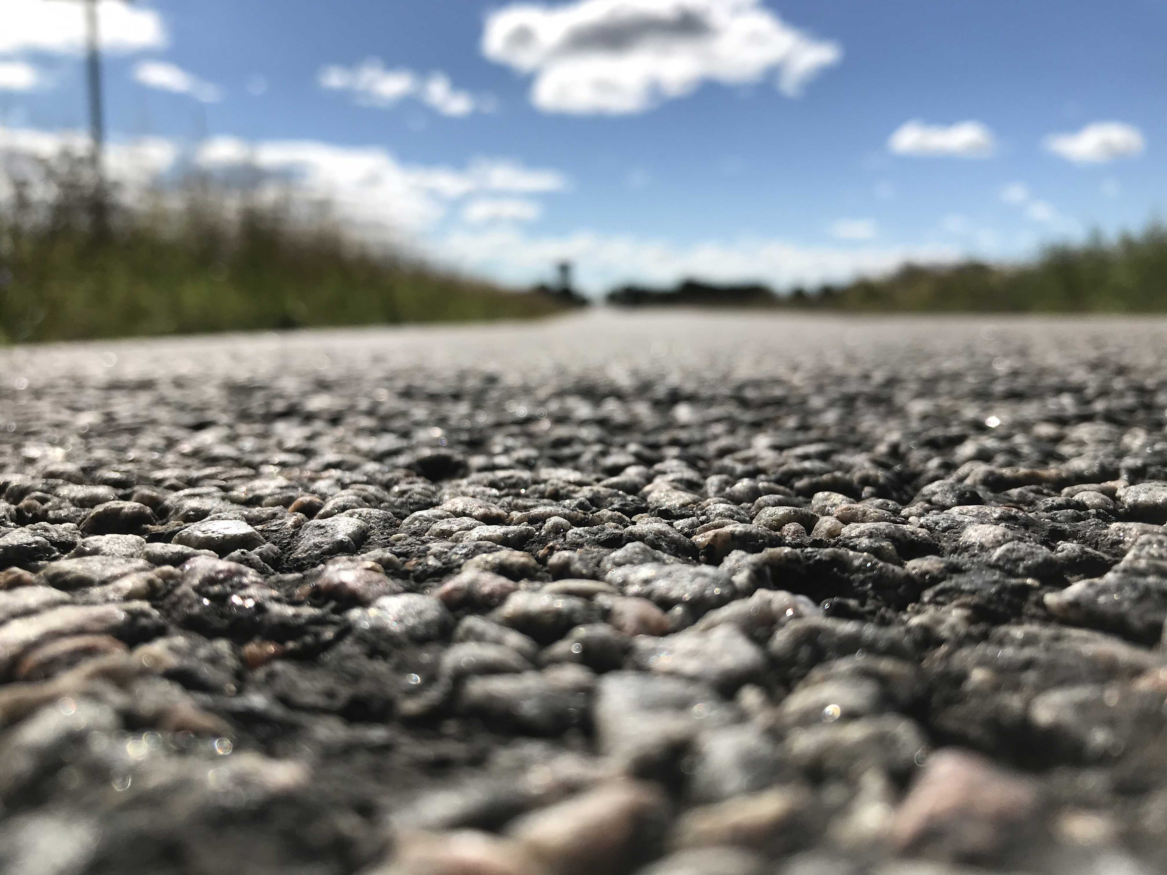 Closeup af en vej hvor man tydeligt ser de småsten en vejbelægning er lavet af