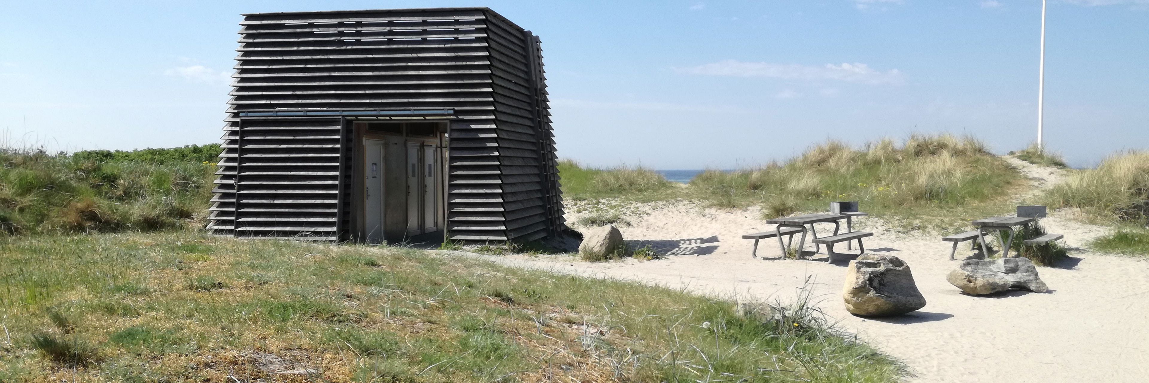 Toiletbygningen på Nordstrandsvej. Der er blå himmel.