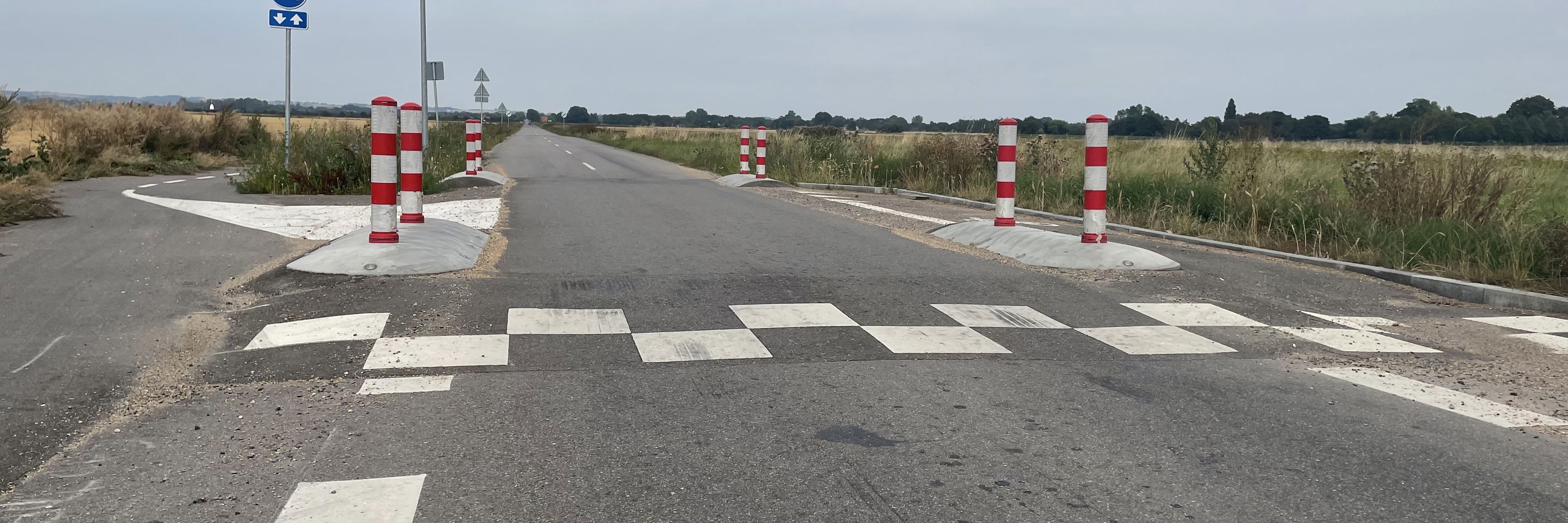 Vejbump med rød/hvide chikaner ude i åbent land
