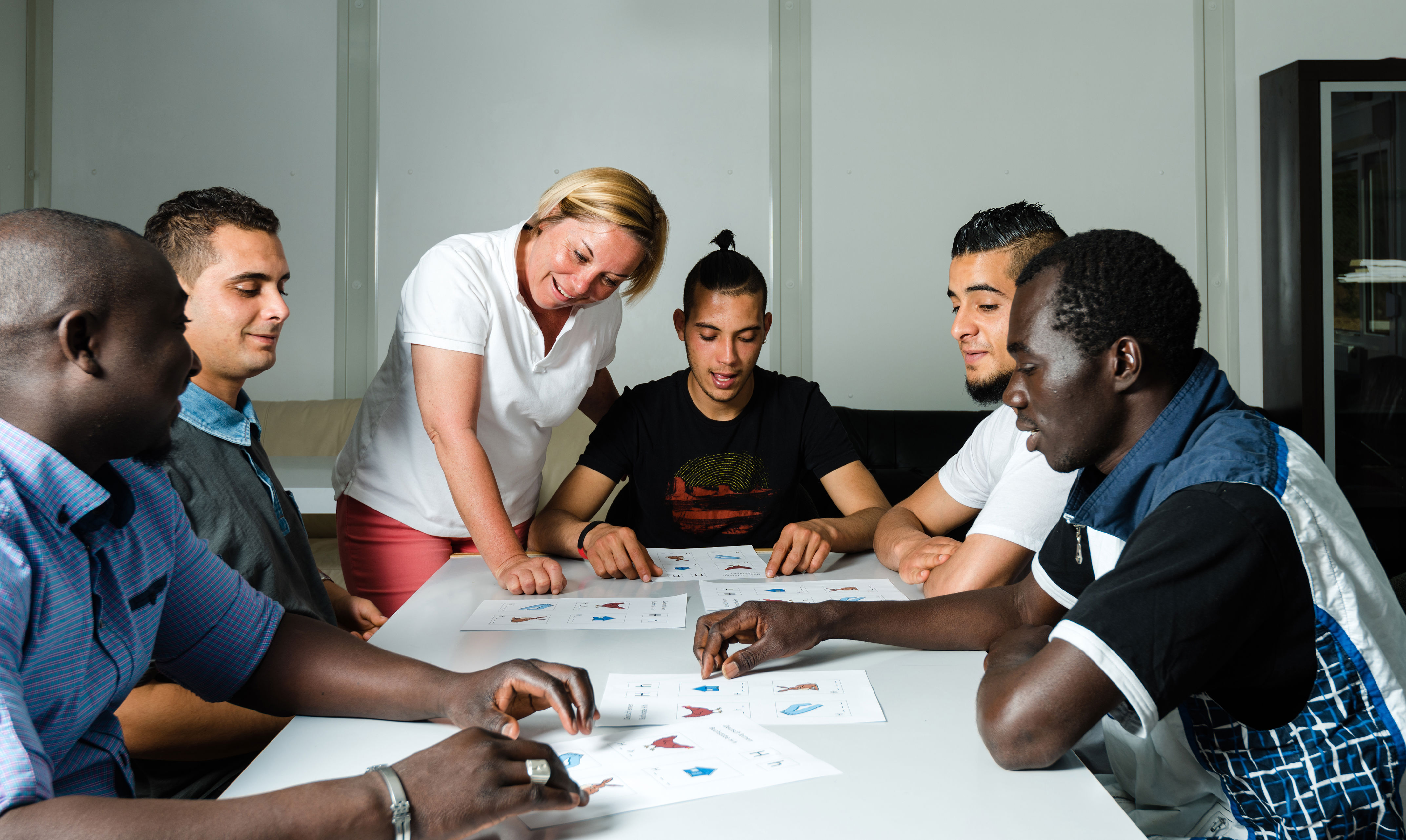 En masse mennesker med forskellig etnisk baggrund sidder omkring et bord