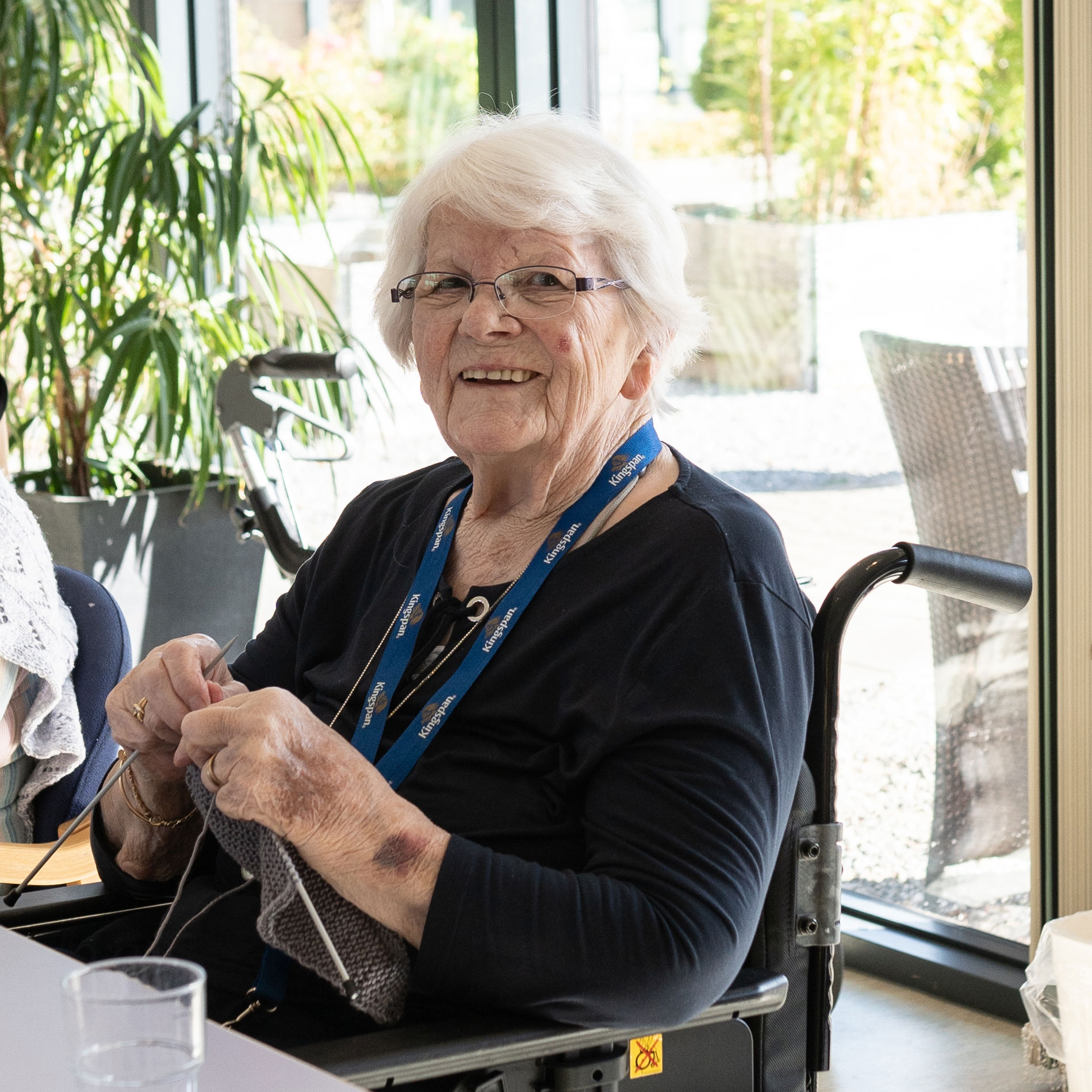 Smilende beboer med sit strikketøj