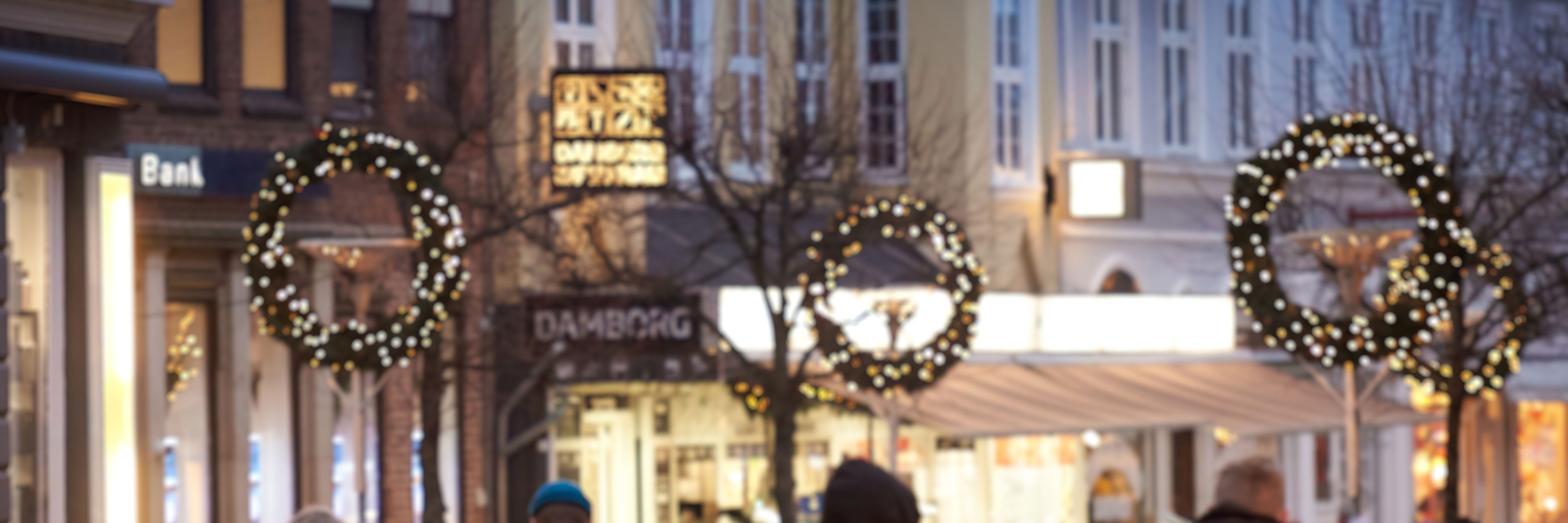 Algade i aftenlys, store kranse og udsmykninger med lys