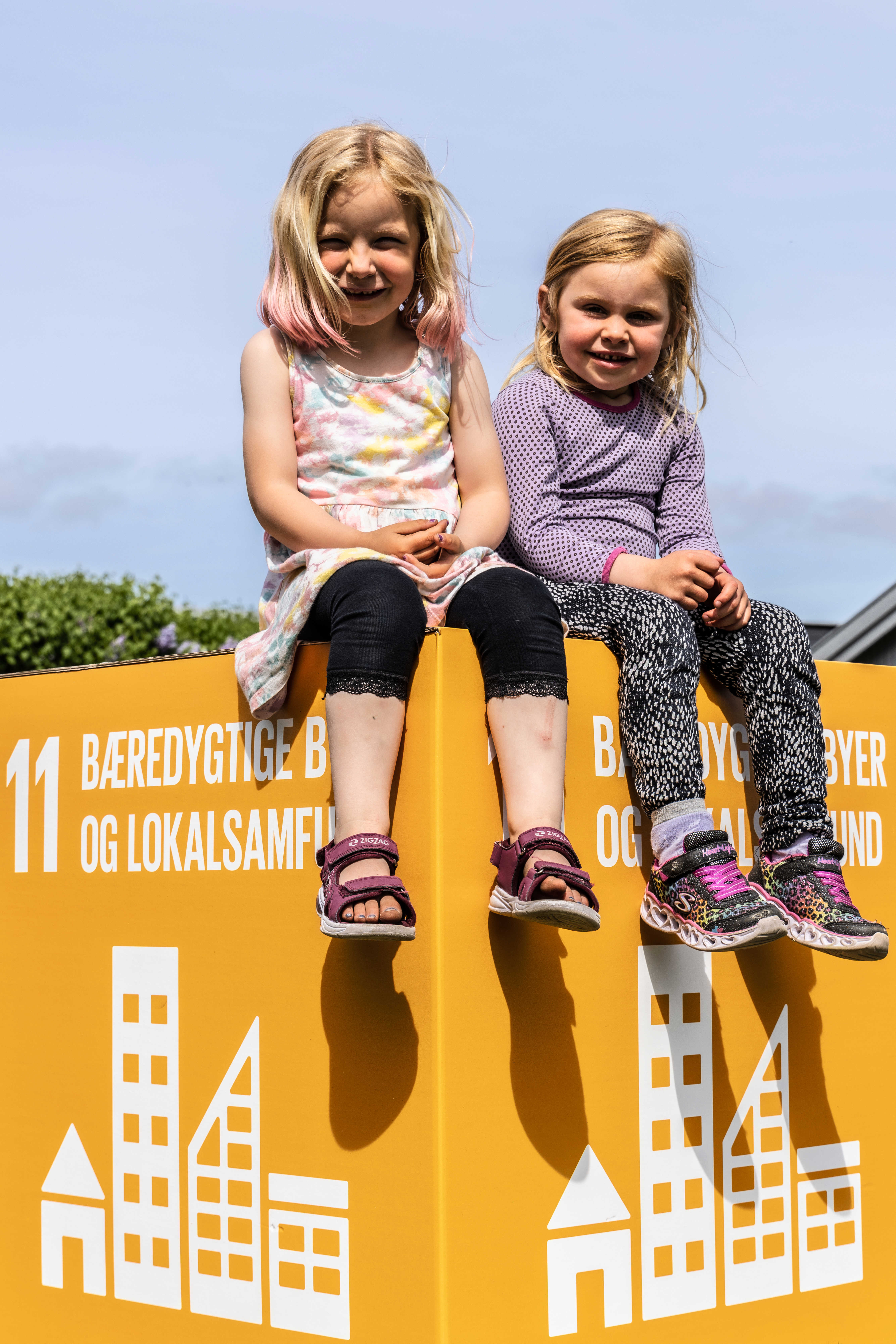 To piger på en kasse med verdensmål 11: bæredygtige byer og lokalsamfund