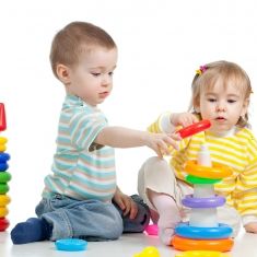 2 børn stabler plastikringe oven på hinanden