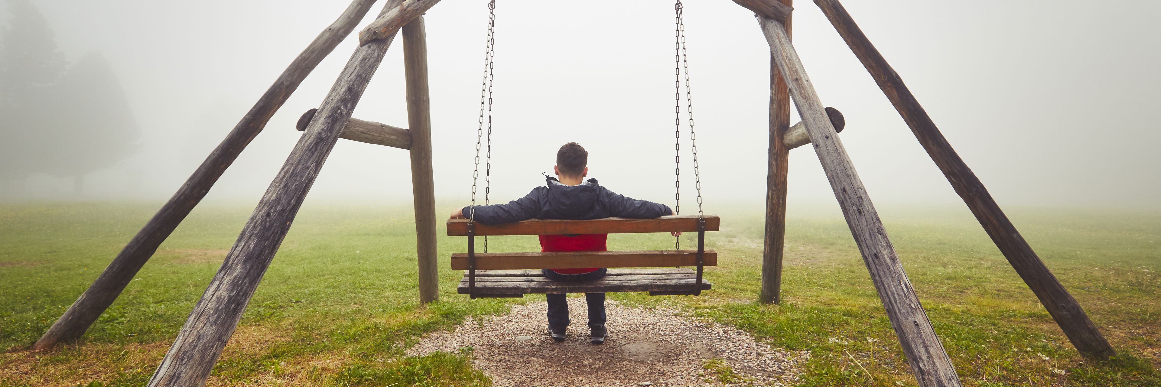Mand alene på gynge - en tåget dag. Ensomhed