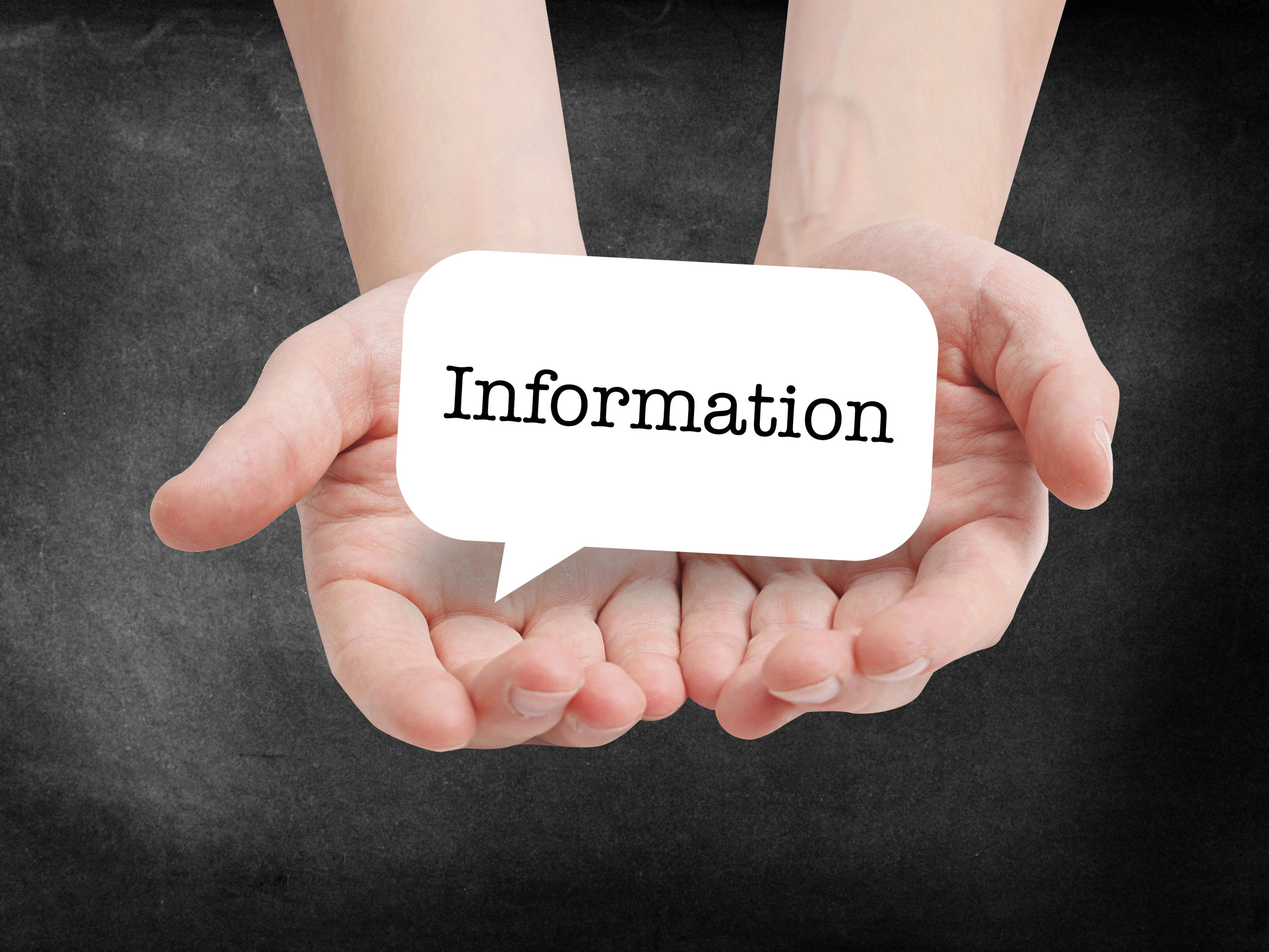 hænder, der holder et informationsskilt