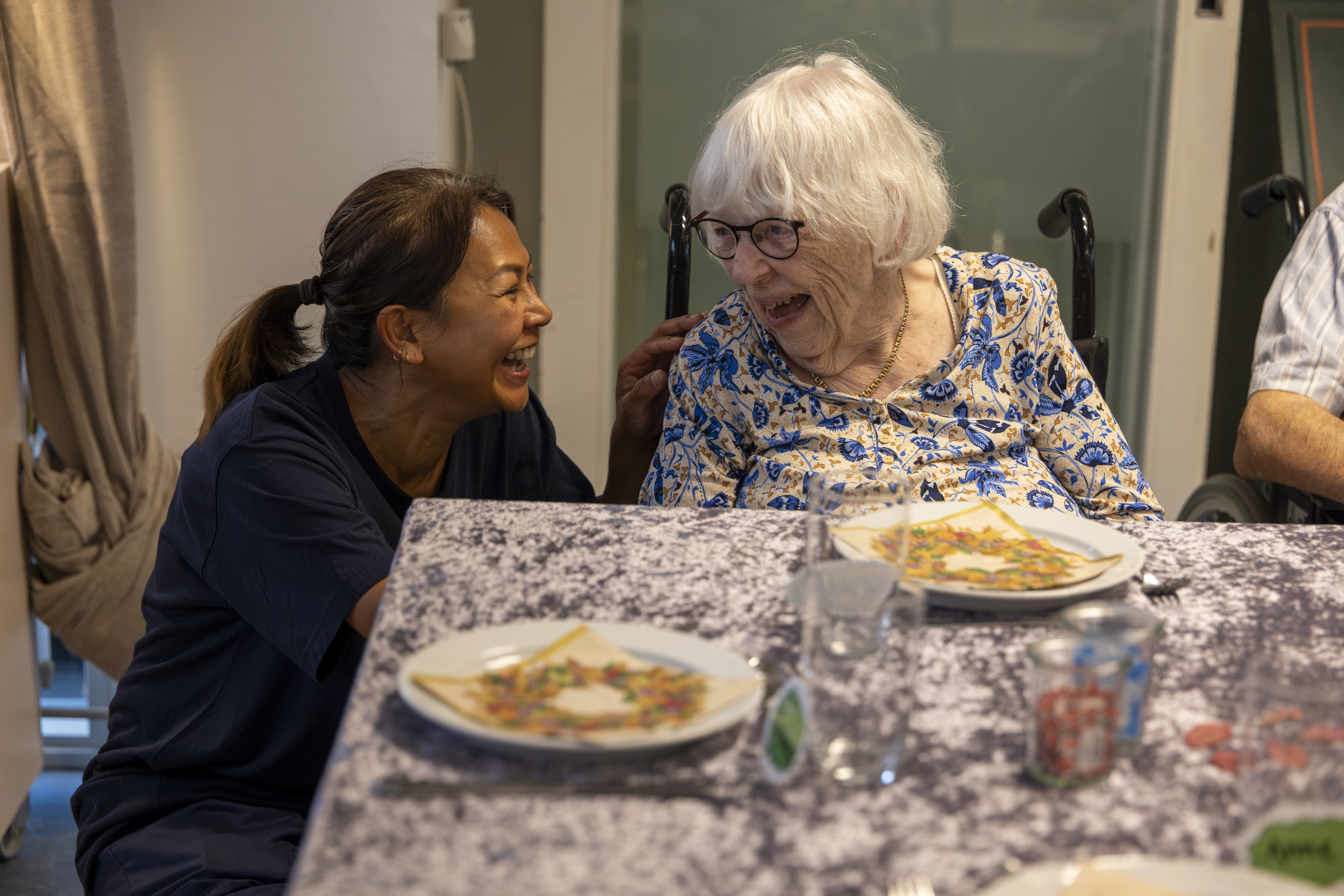 To kvinder griner sammen ved et bord