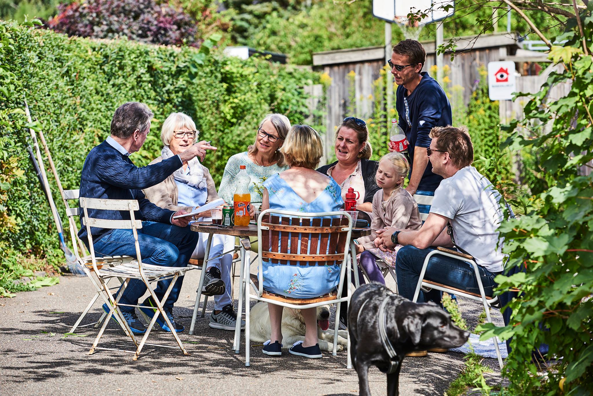 Mennesker der sidder ved et havebord