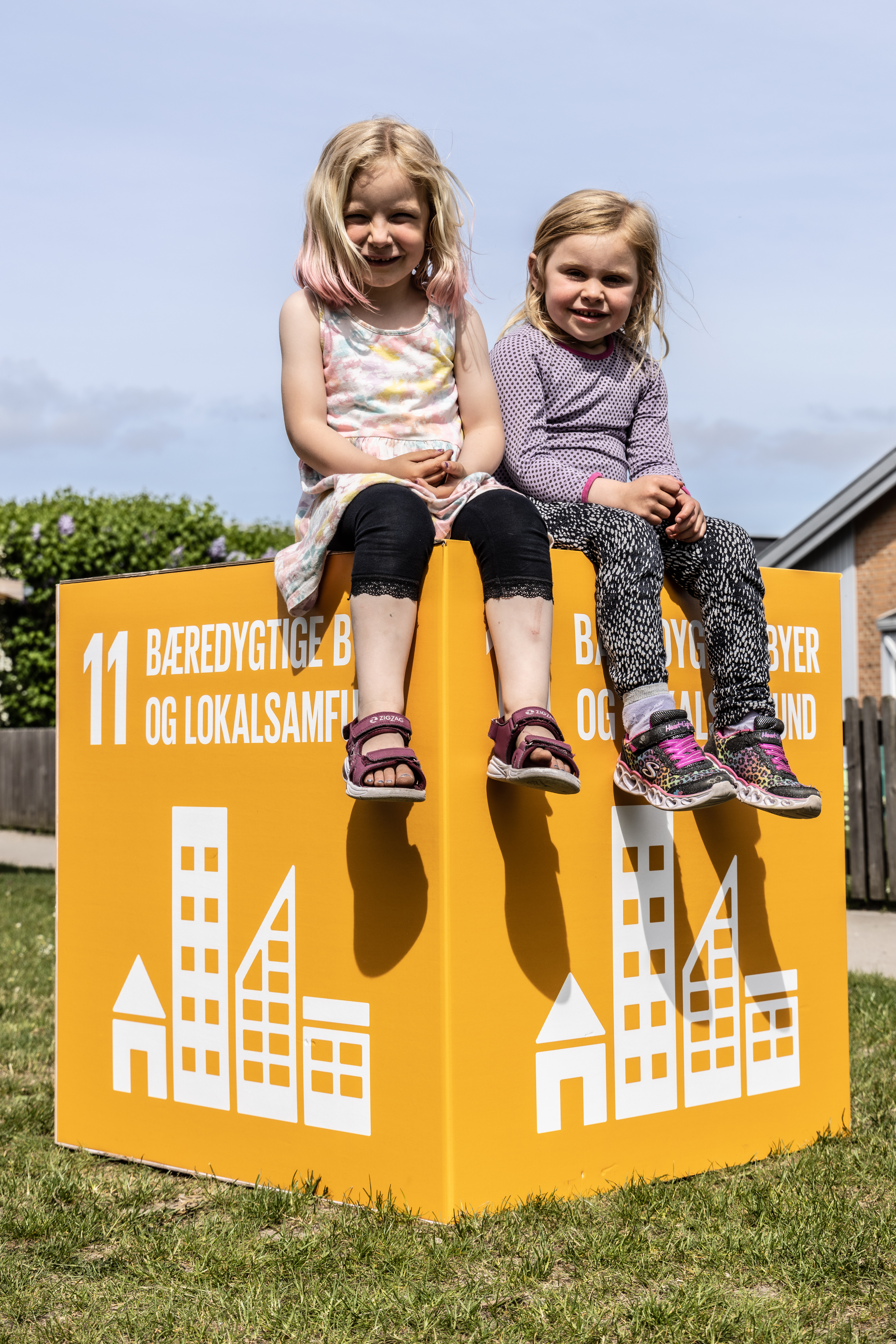 To piger på en kasse med verdensmål 11: bæredygtige byer og lokalsamfund