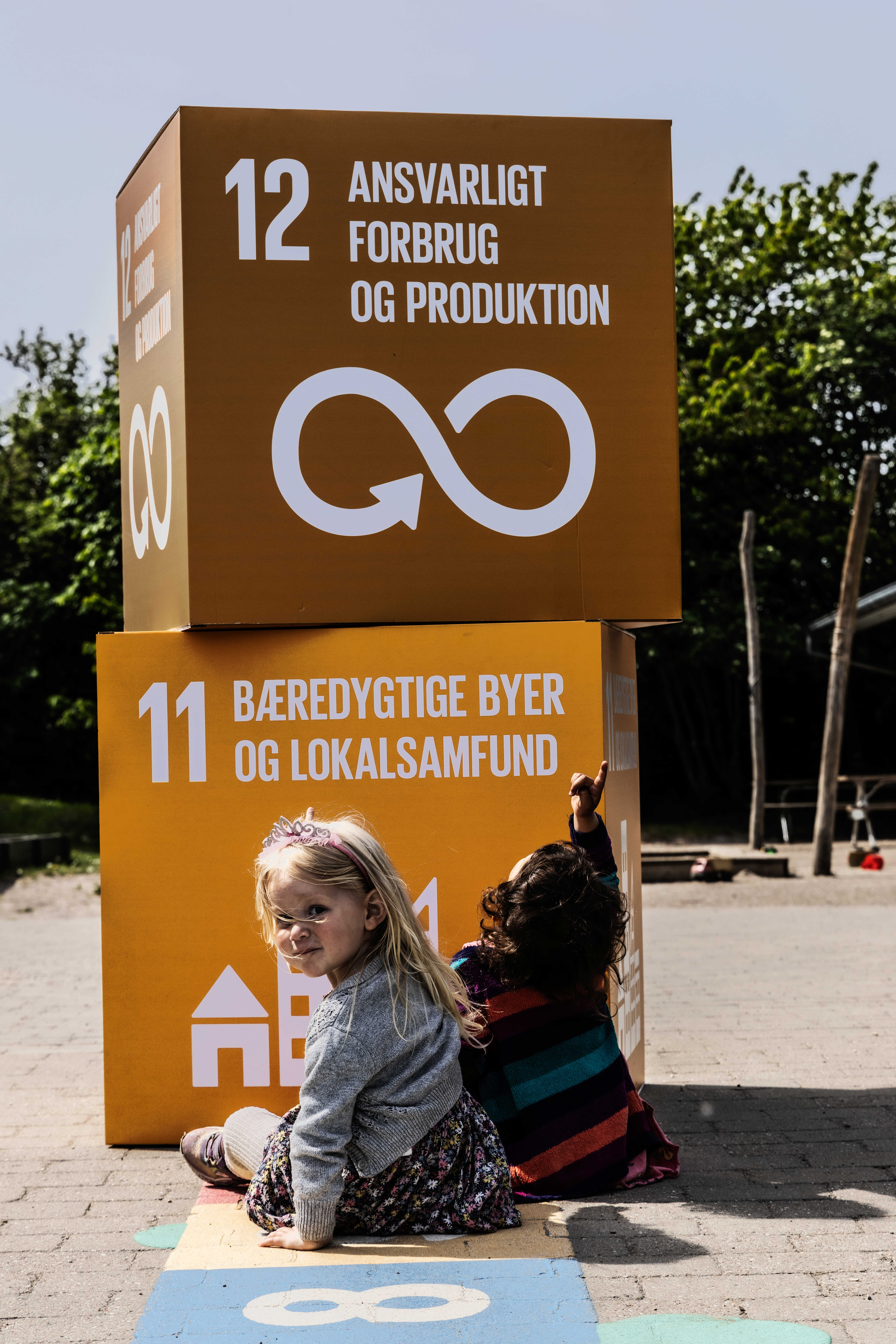 Børn peger på kasser med verdensmålene